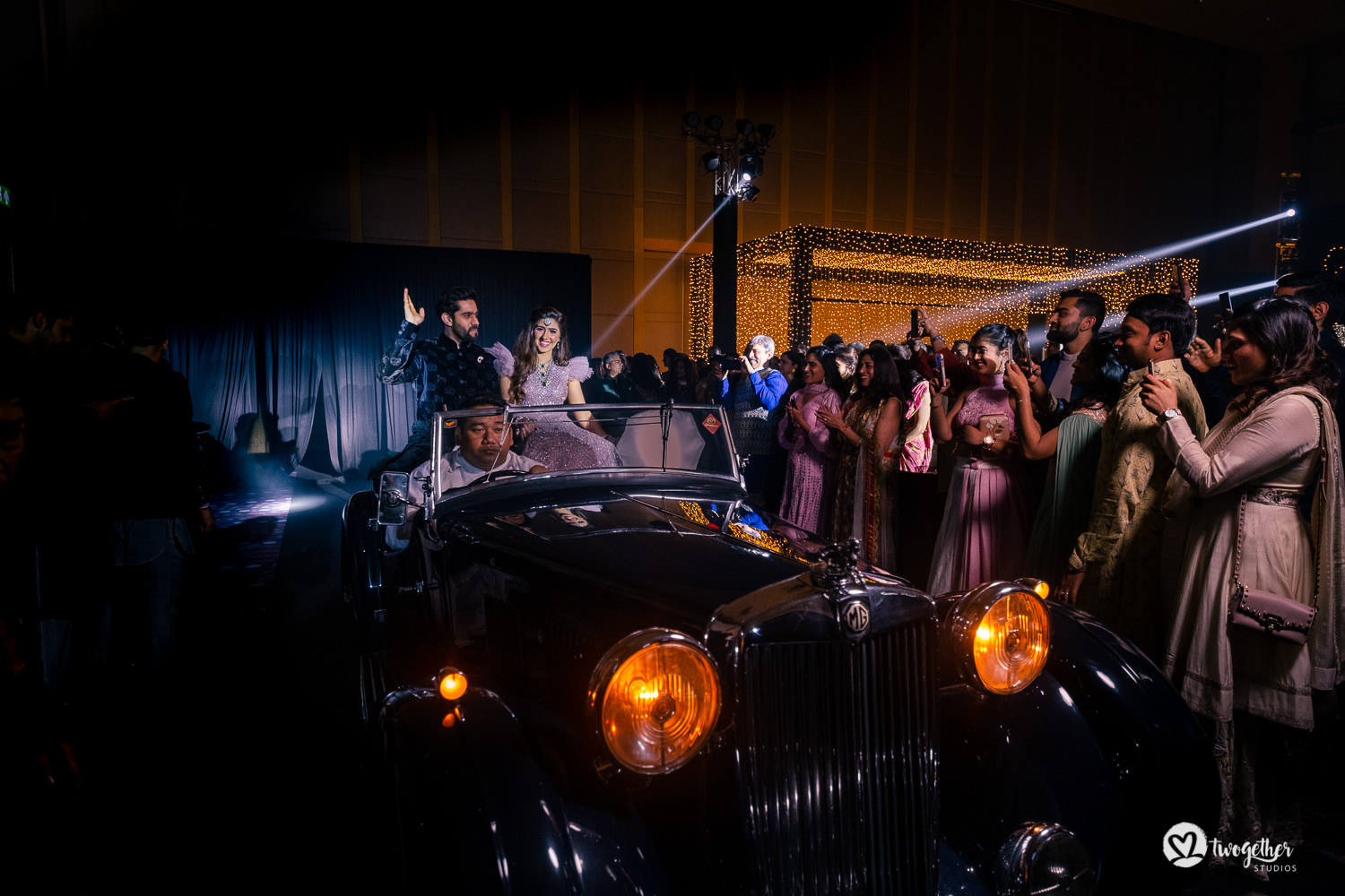 Indian couple entry in a vintage car at sangeet in Bangkok destination wedding.